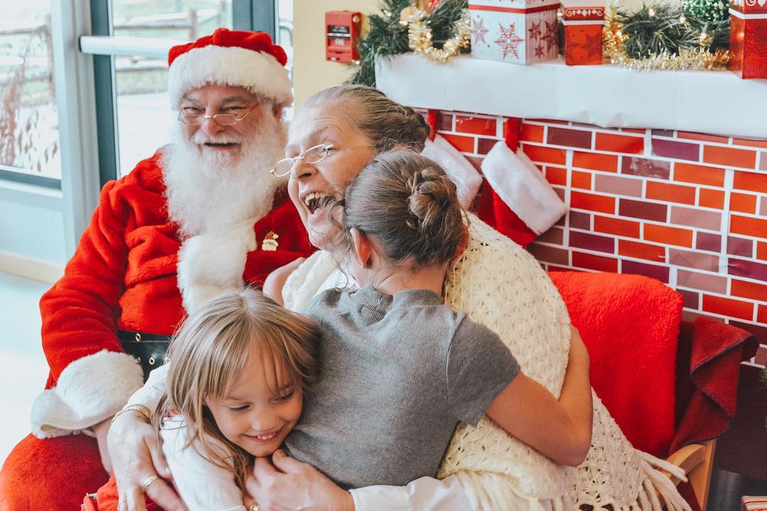 Little kids hugging Santa Claus. Photo by Instagram user @linabondaca