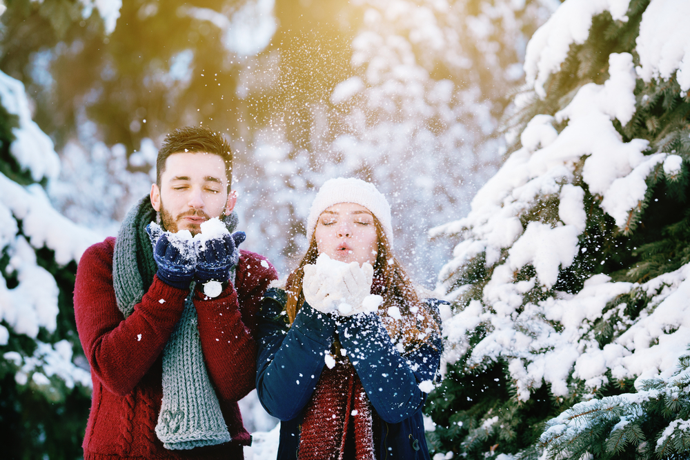Guy and girl blowing snow.