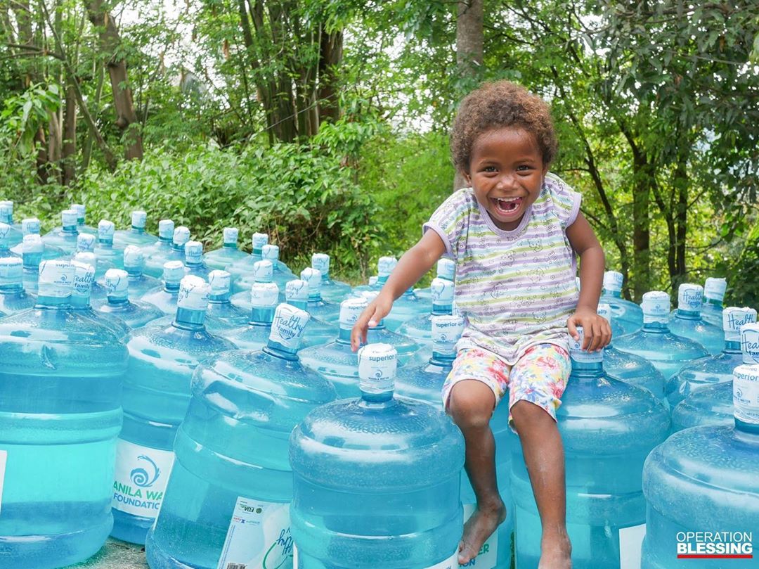 Little girl sitting on jugs of water. Photo by Instagram user @obphil