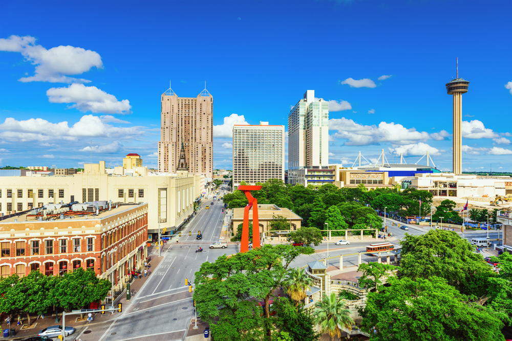 Skyline of tall buildings and green trees on sunny day in Downtown San Antonio.