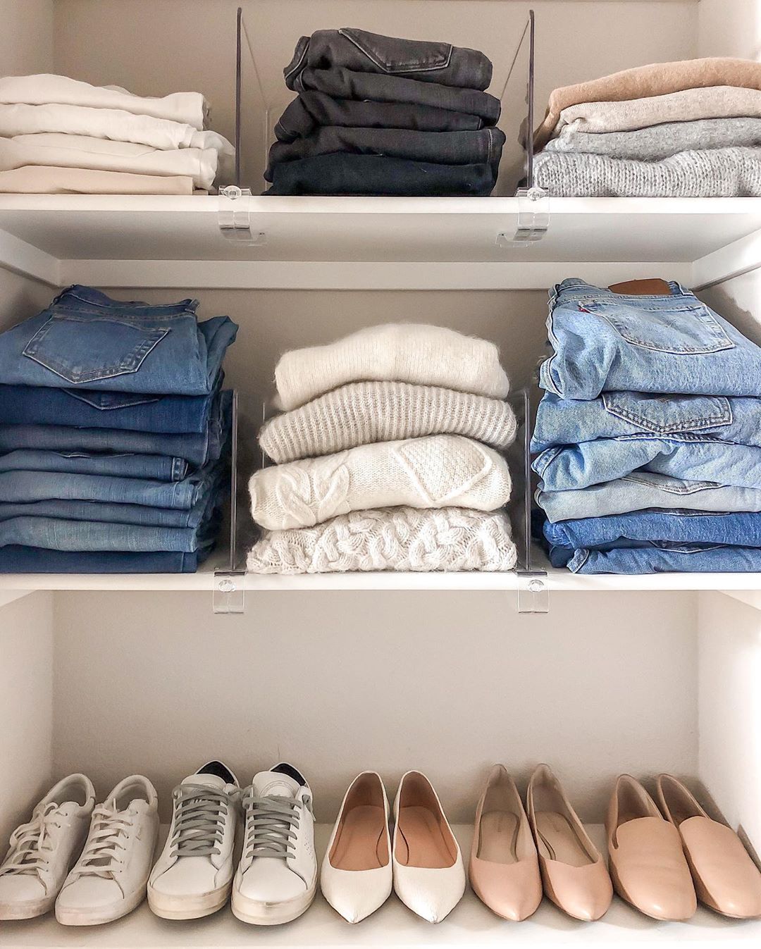 Sweaters and jeans folded on shelves. Photo by Instagrma user @girlmeetsgold