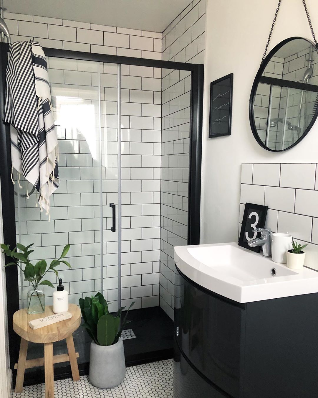 White and black small bathroom with round mirror. Photo by Instagram user @nest_twenty_eight