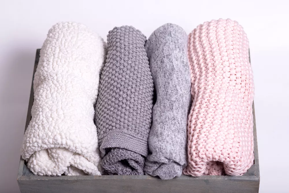 Four sweaters folded in a box