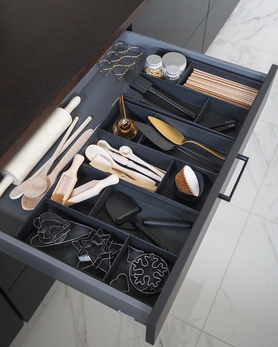 Utensils organized in black drawer. Photo by Instagram user @marj0085