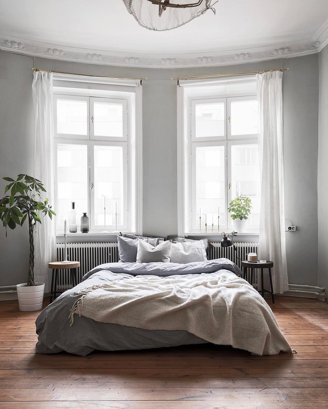 Gray bedroom with platform bed and wood floors. Photo by Instagram user @kronfoto