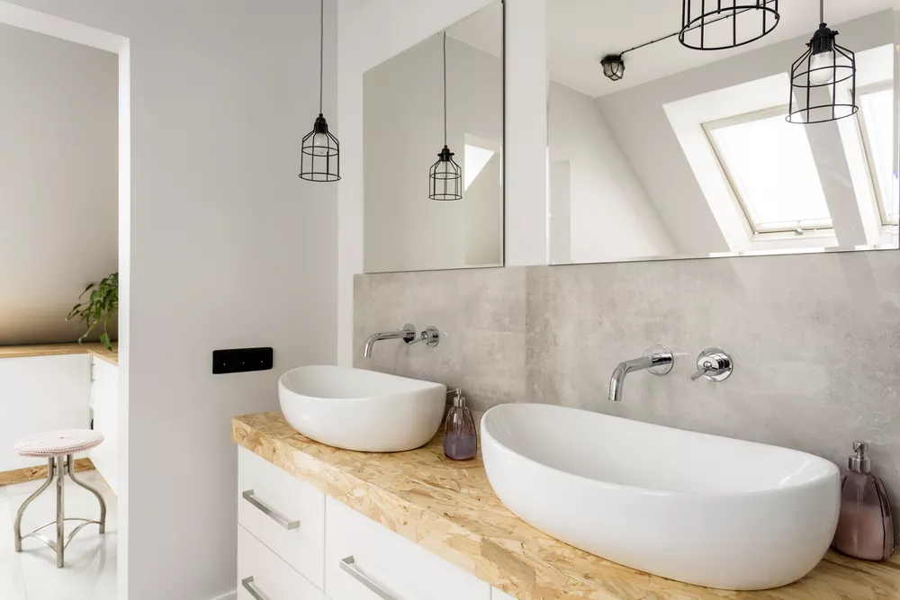 White bathroom with wood counters and white sinks.