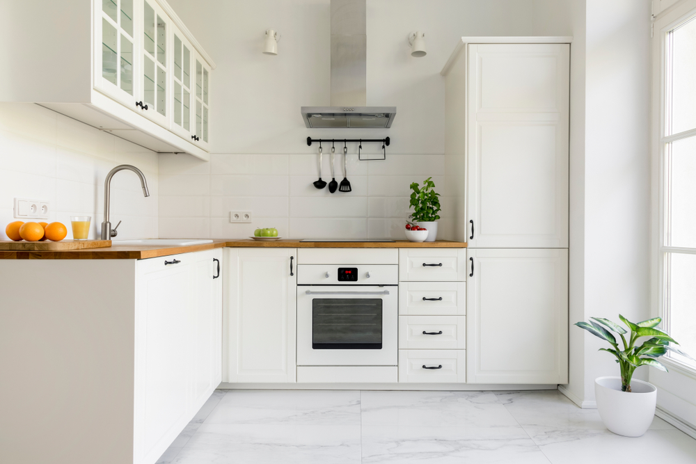 A clean white kitchen with wooden countertops