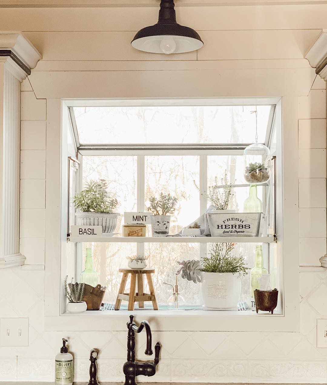 Kitchen window sill holding plants. Photo by Instagram user @rustyrosefarmhouse