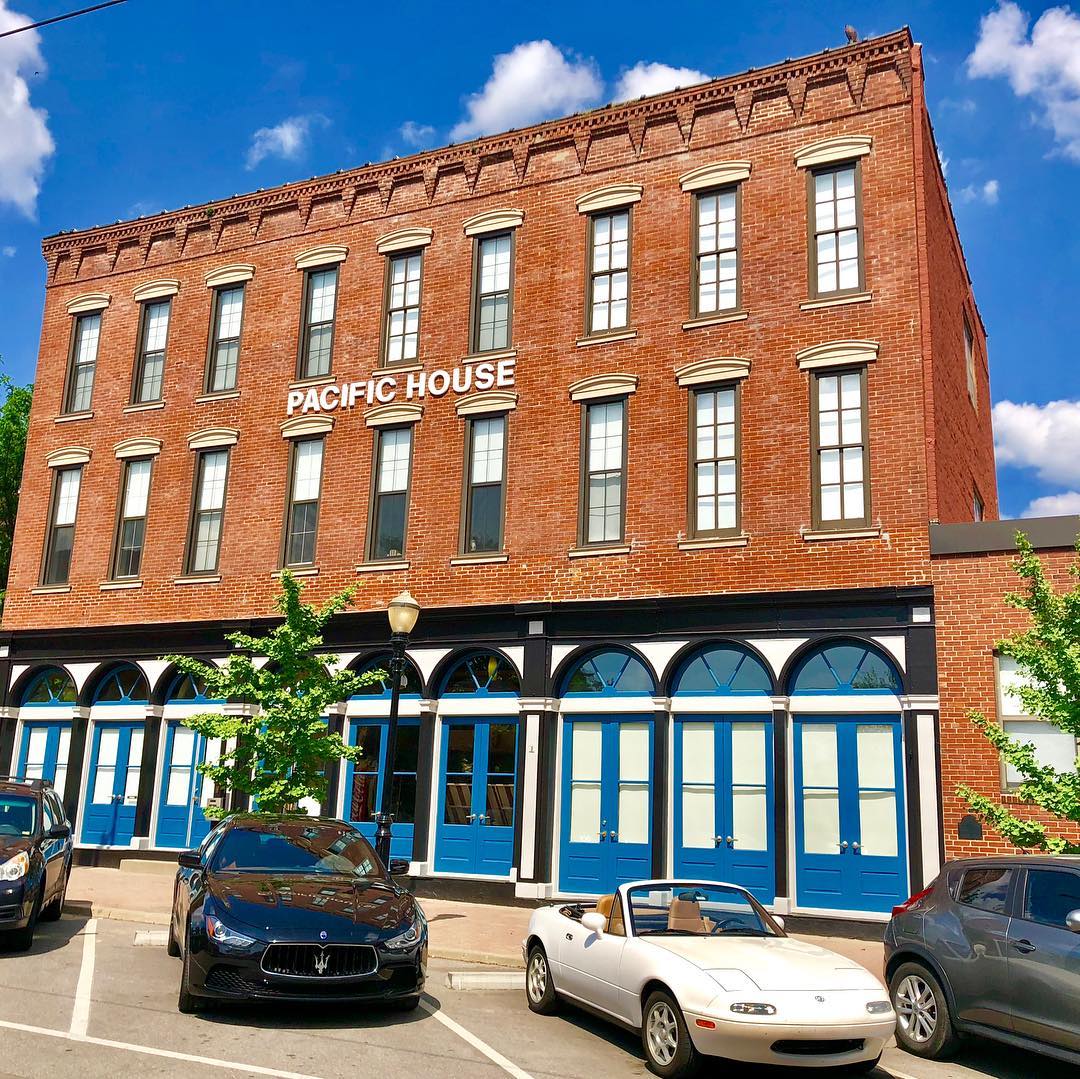 Red brick building with blue windows in River Market. Photo by Instagram user @thelandingsatrivermarket