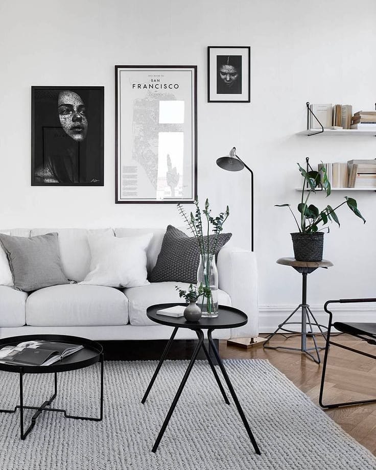 Gray living room with gray couch, wood floor, and black tables. Photo by Instagram user @designingyourhome