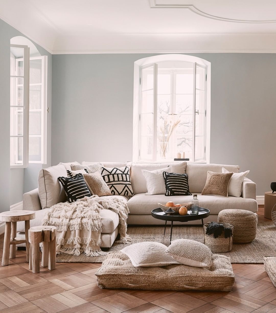 Gray living room with wood floors and white couch. Photo by Instagram user @westwingde