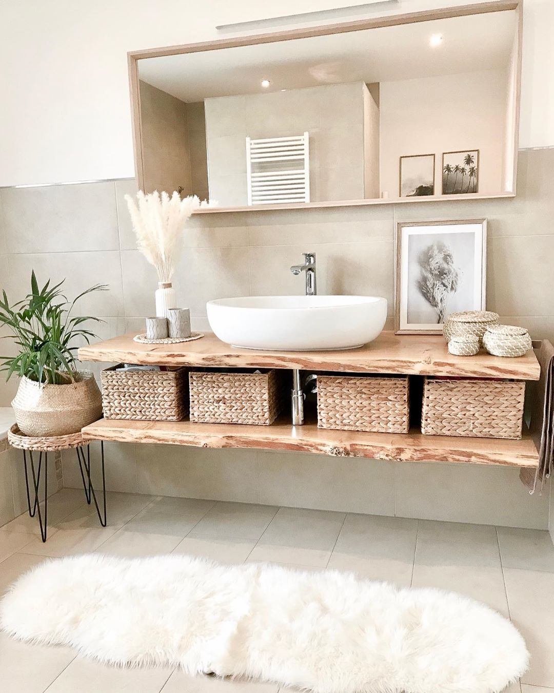 White bathroom with wood floating cabinet and white faux fur rug. Photo by Instagram user @kati_home13
