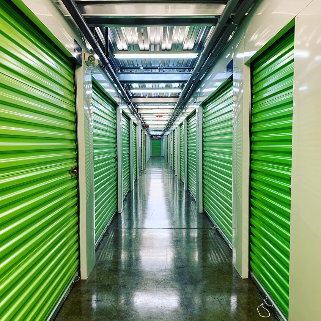 Hallway of storage units with green doors. Photo by Instagram user @tentpitcher