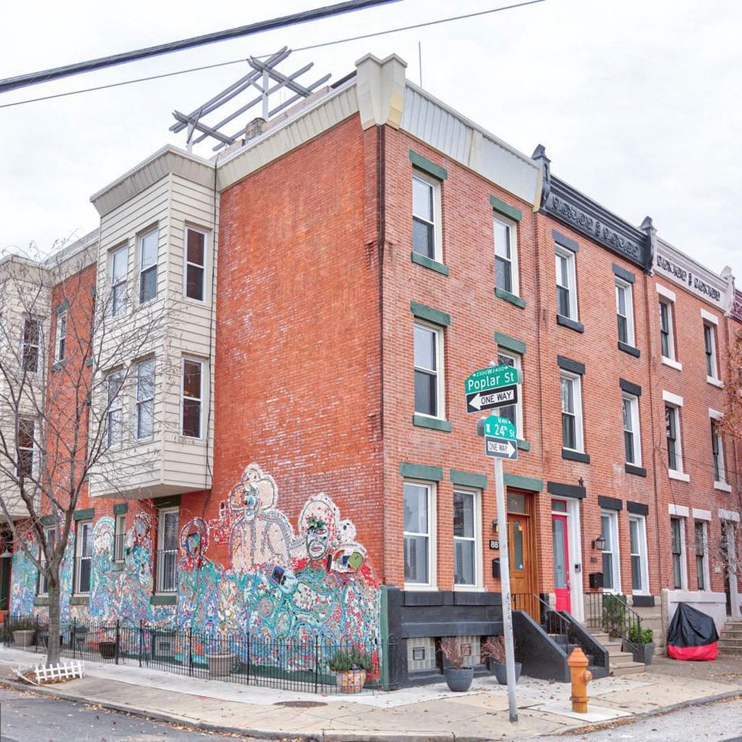 Red brick apartment building with mural on side in Fairmount, Philadelphia. Photo by Instagram user @phillymag