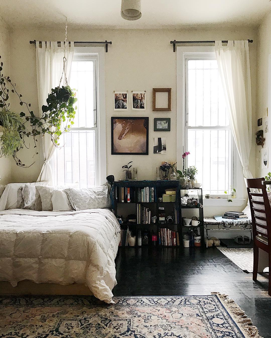All white bedroom with dark floors in apartment. Photo by Instagram user @etshipley