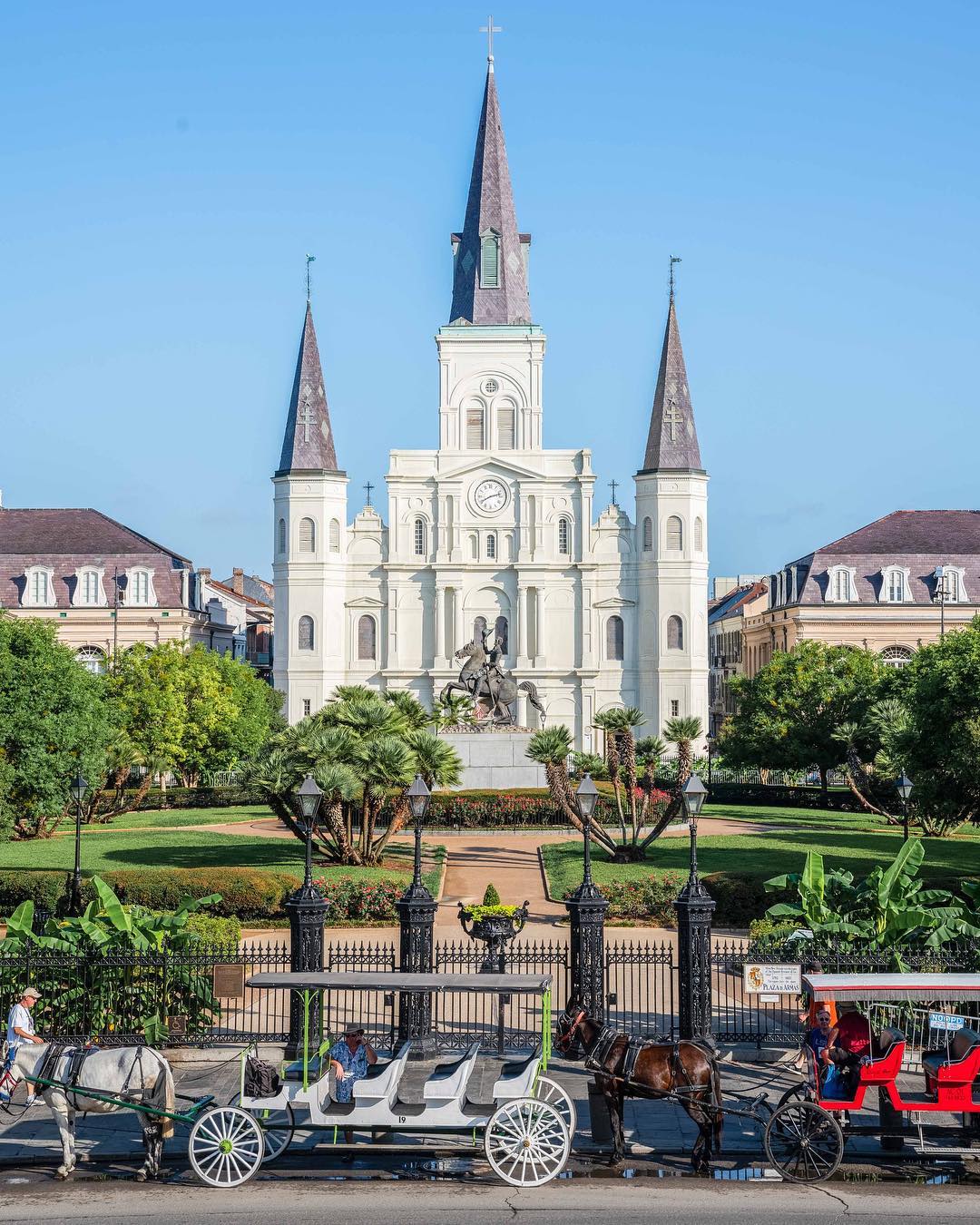 Horse-drawn carriages in front of white cathedral in New Orleans. Photo by Instagram user @gettingstamped
