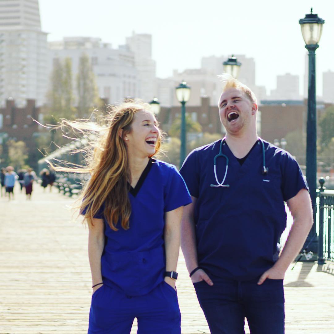Male and female nurse laughing while walking down the sidewalk. Photo by Instagram user @trustedhealth