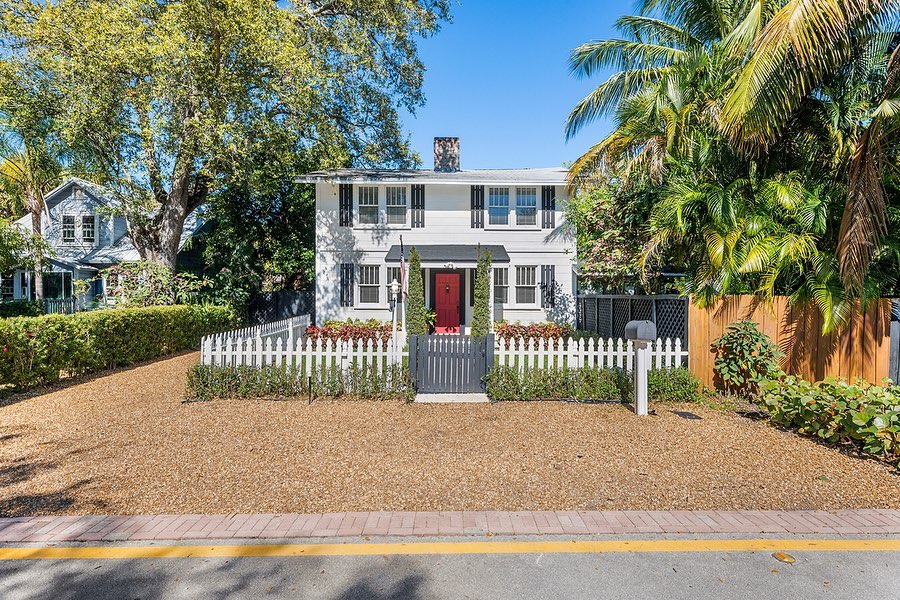 White house with red door and picket fence in Sailboat Bend, Fort Lauderdale, FL. Photo by Instagram user @thepolskygroup
