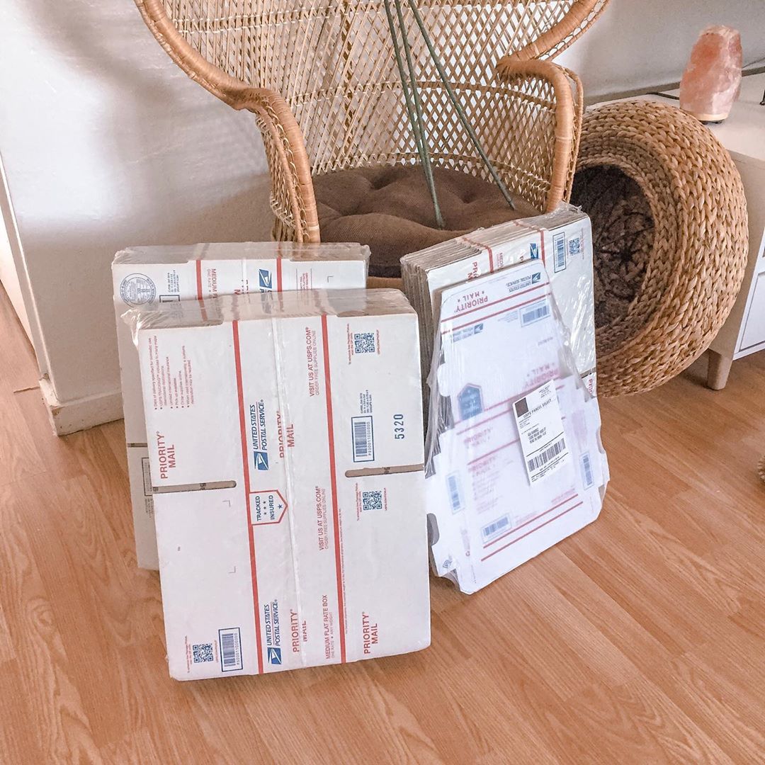 Packs of USPS boxes by chair. Photo by Instagram user @h0llaaaaaa