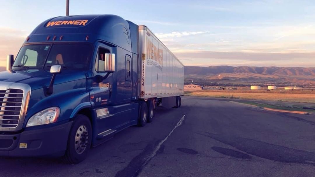 Blue and white semi on road ring sunset. Photo by Instagram user @one_werner