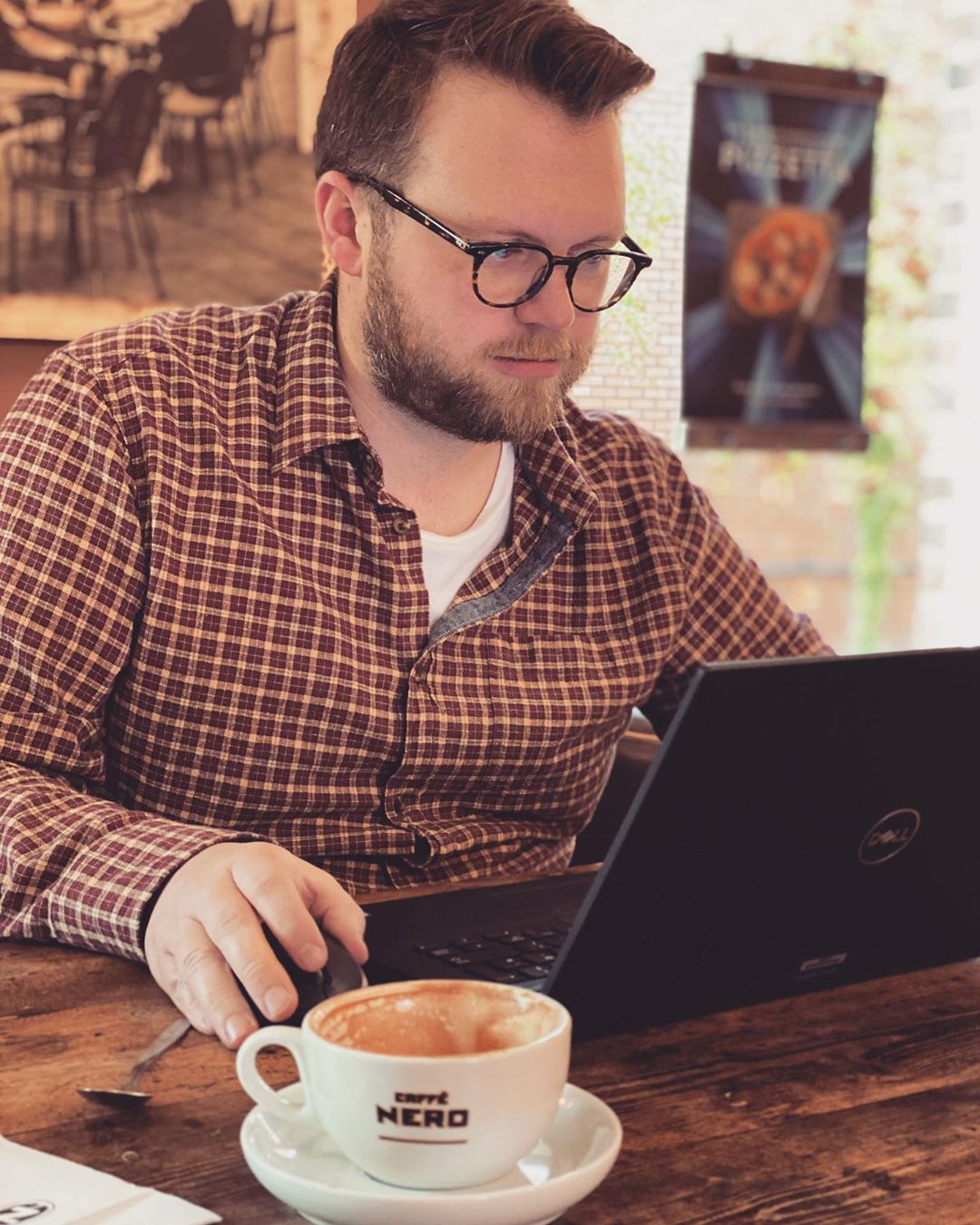 Guy sitting at coffee shop with computer. Photo by Instagram user @shauny2270