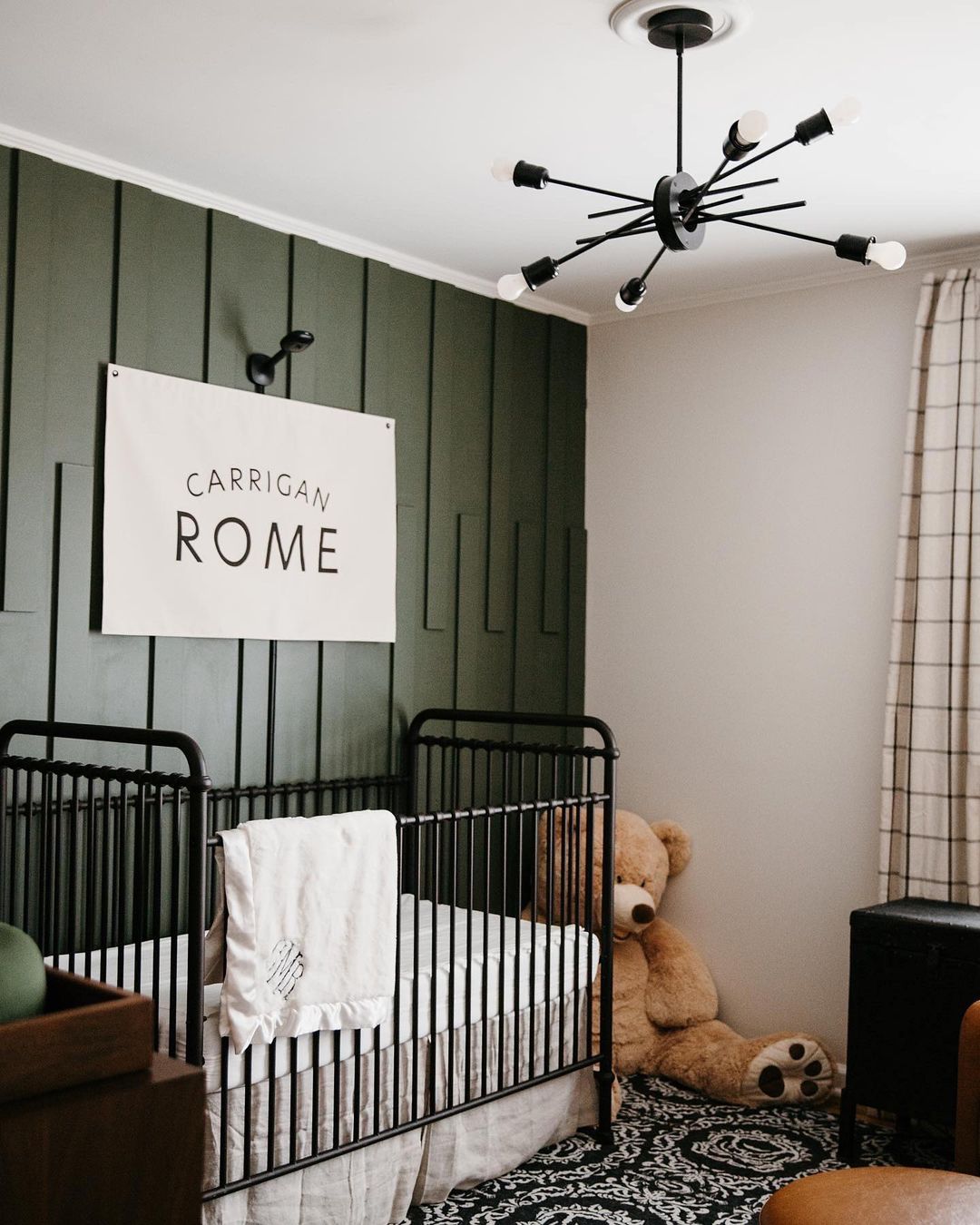 A green accent wall with name art in a baby nursery. Photo by Instagram user @houseofmartinhomes