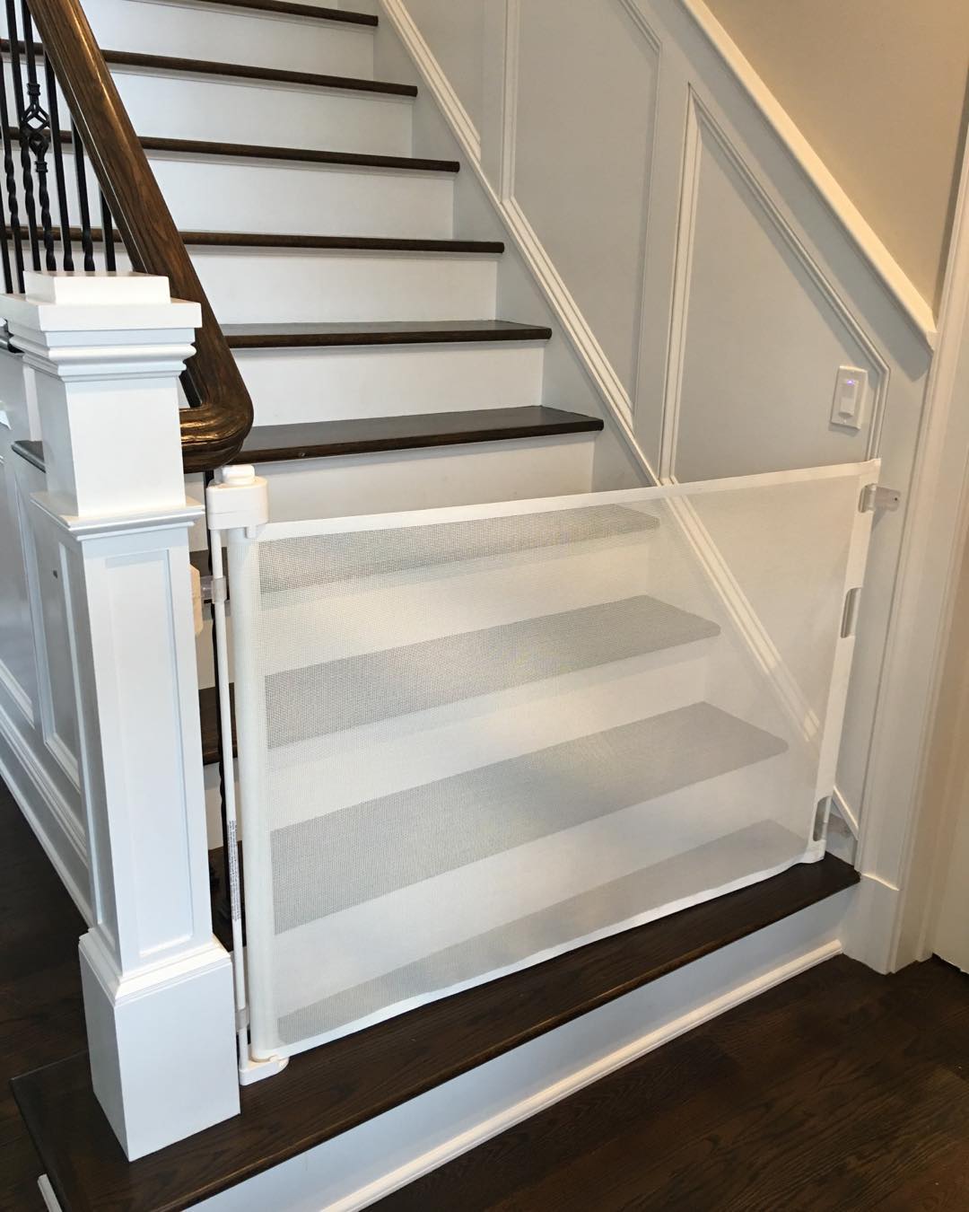 Baby gate installed at bottom of stairs. Photo by @pbandjbabyproofing_playrooms