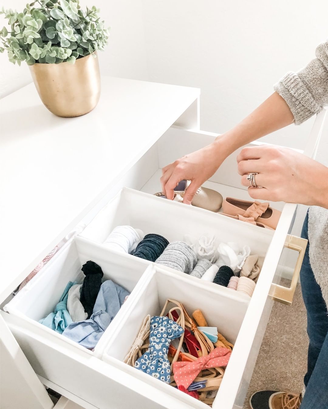 dresser drawer filled with baby clothes with drawer organizers photo by Instagram user @britneetanner