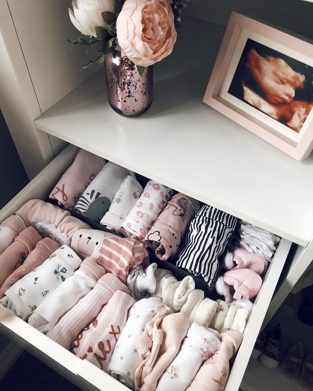 drawer filled with file folded baby clothes with sonogram image photo by Instagram user @hayitssamk