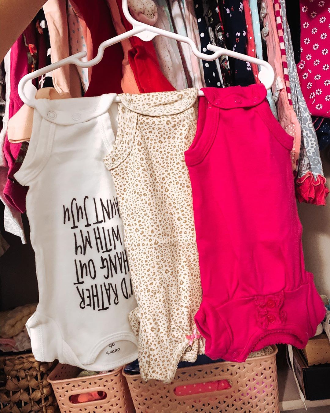 hanger with multiple baby clothes hanging off of it photo by Instagram user @joelle_mcclune