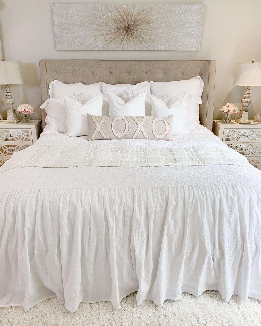 White bed with tan pillows.