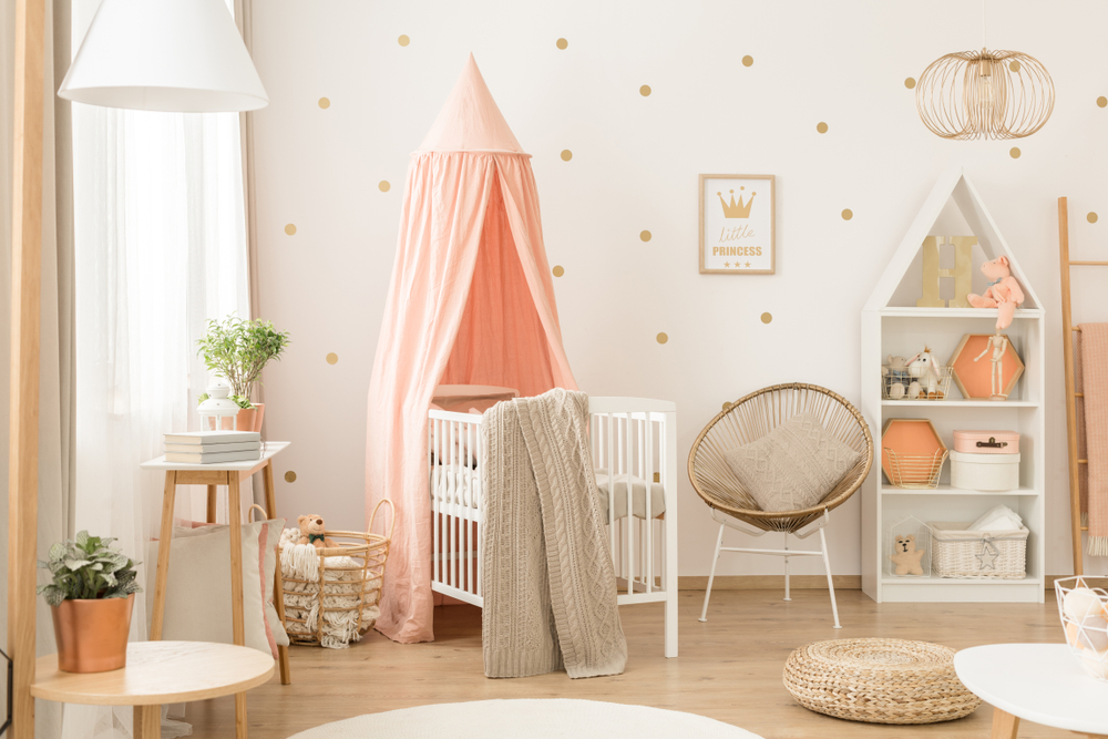 Baby room with white crib pink canopy.