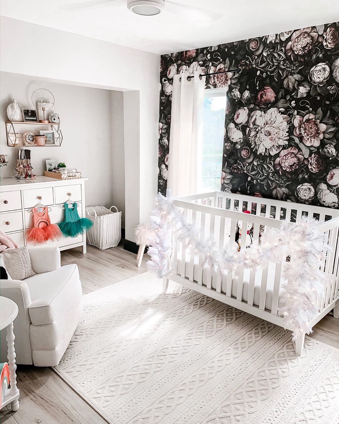 White nursery with black floral wall. Photo by Instagram user @the_floridagirl
