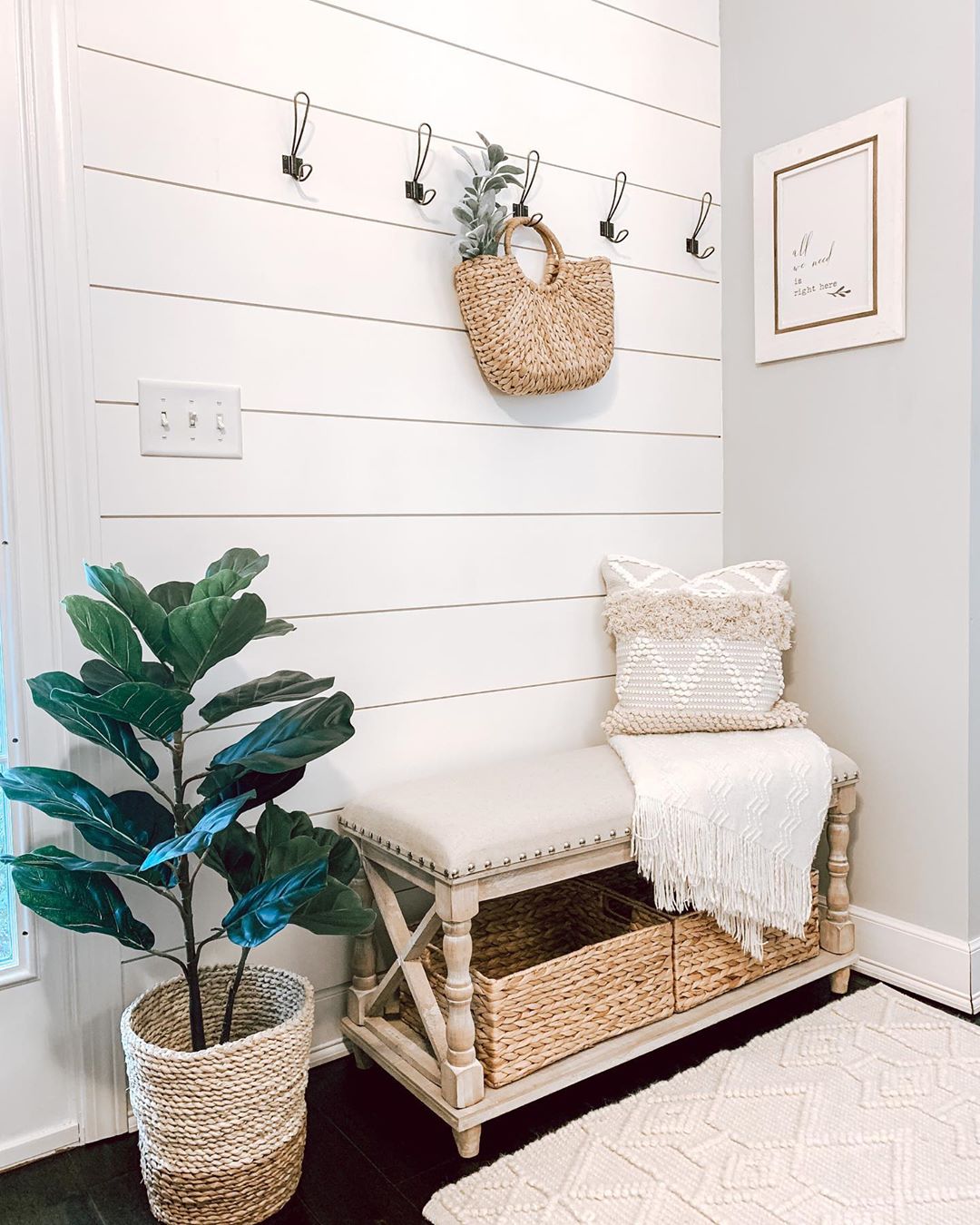 Tan bench in all white entryway.