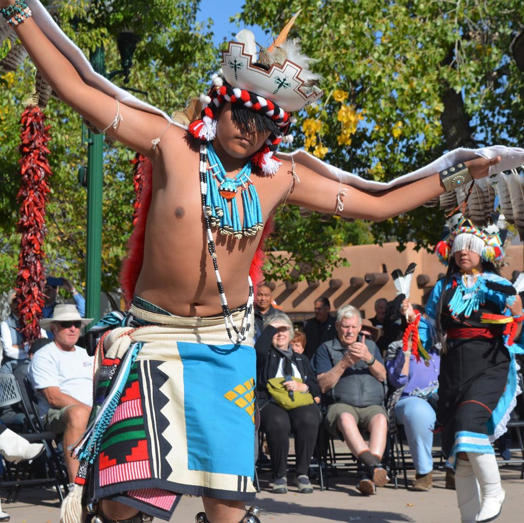 man dancing in traditional native american dress photo by Instagram user @cityofsantafe