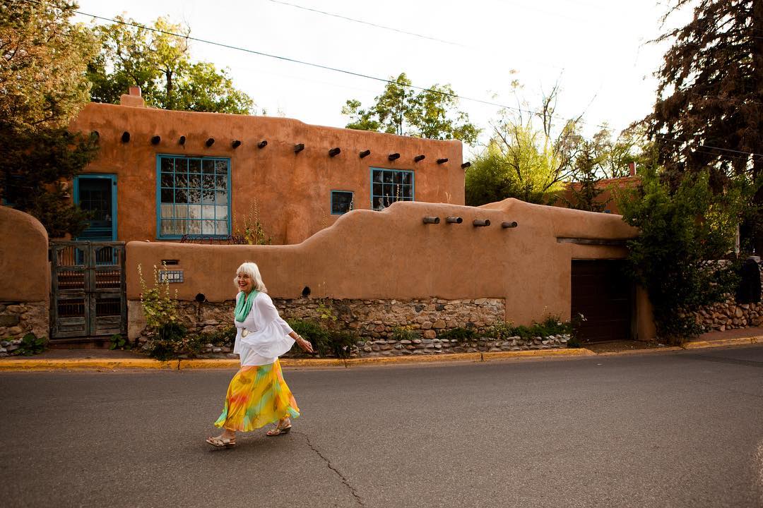 old woman with gray hair walking in the street in santa fe photo by Instagram user @cityofsantafe