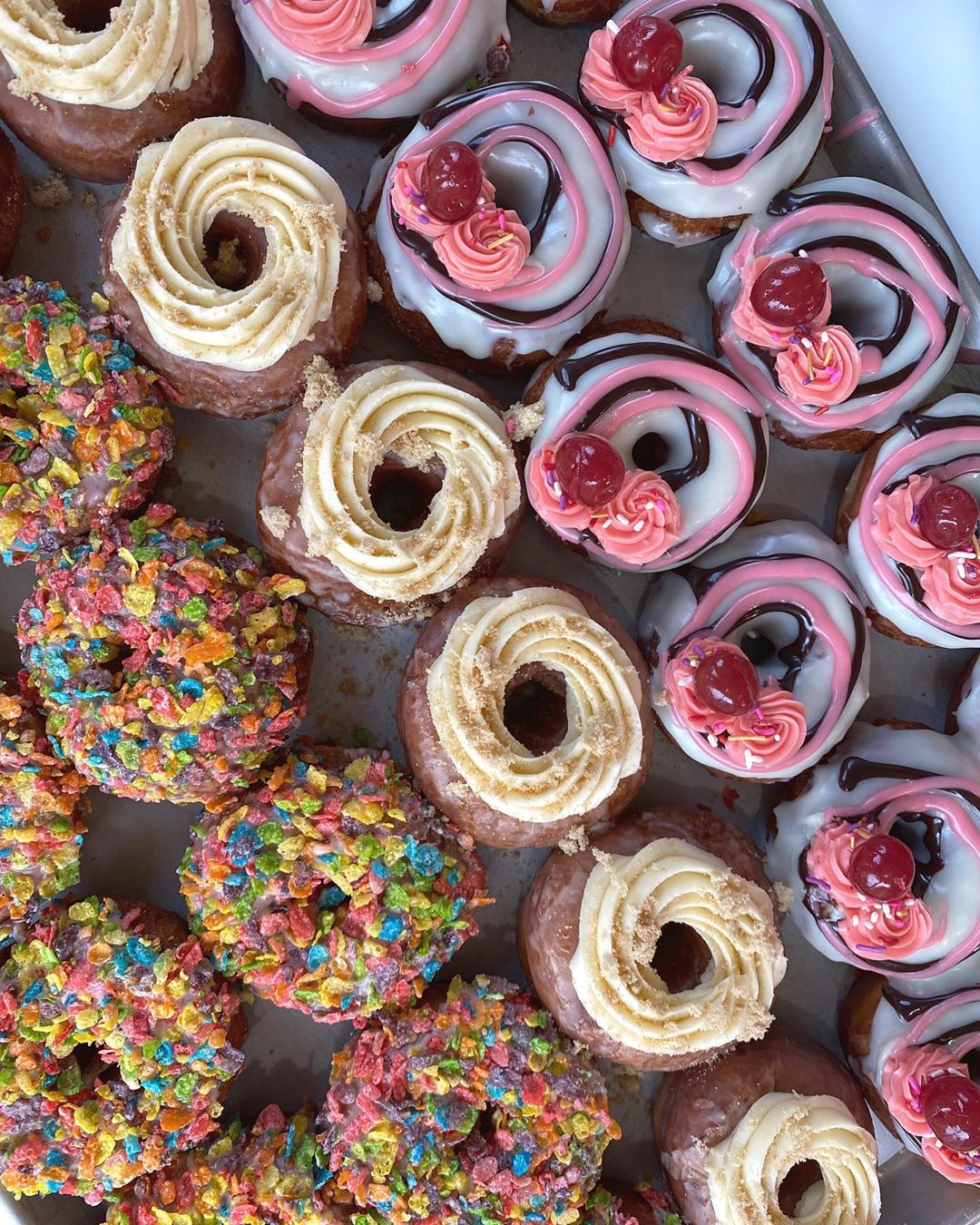 Donuts topped with fruity pebbles, cream cheese frosting and cherries from PV Donuts photo by Instagram user @pvdonuts