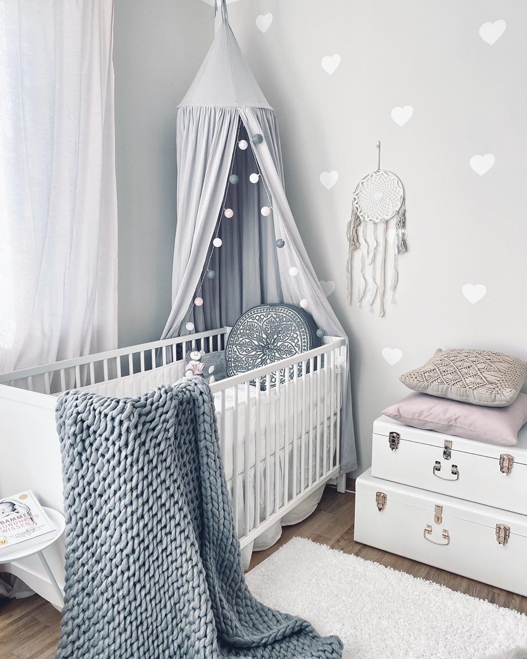 Gray baby room with white hearts and white furniture. Photo by Instagram user @girlsbabyroom