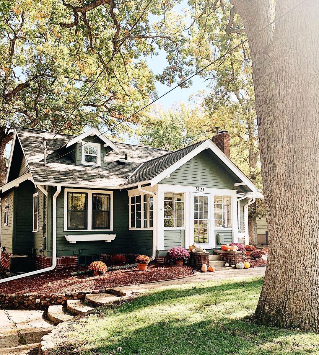 green home with white trim in the sunlight with nice landscaping in the fall photo by Instagram user @brightenmade