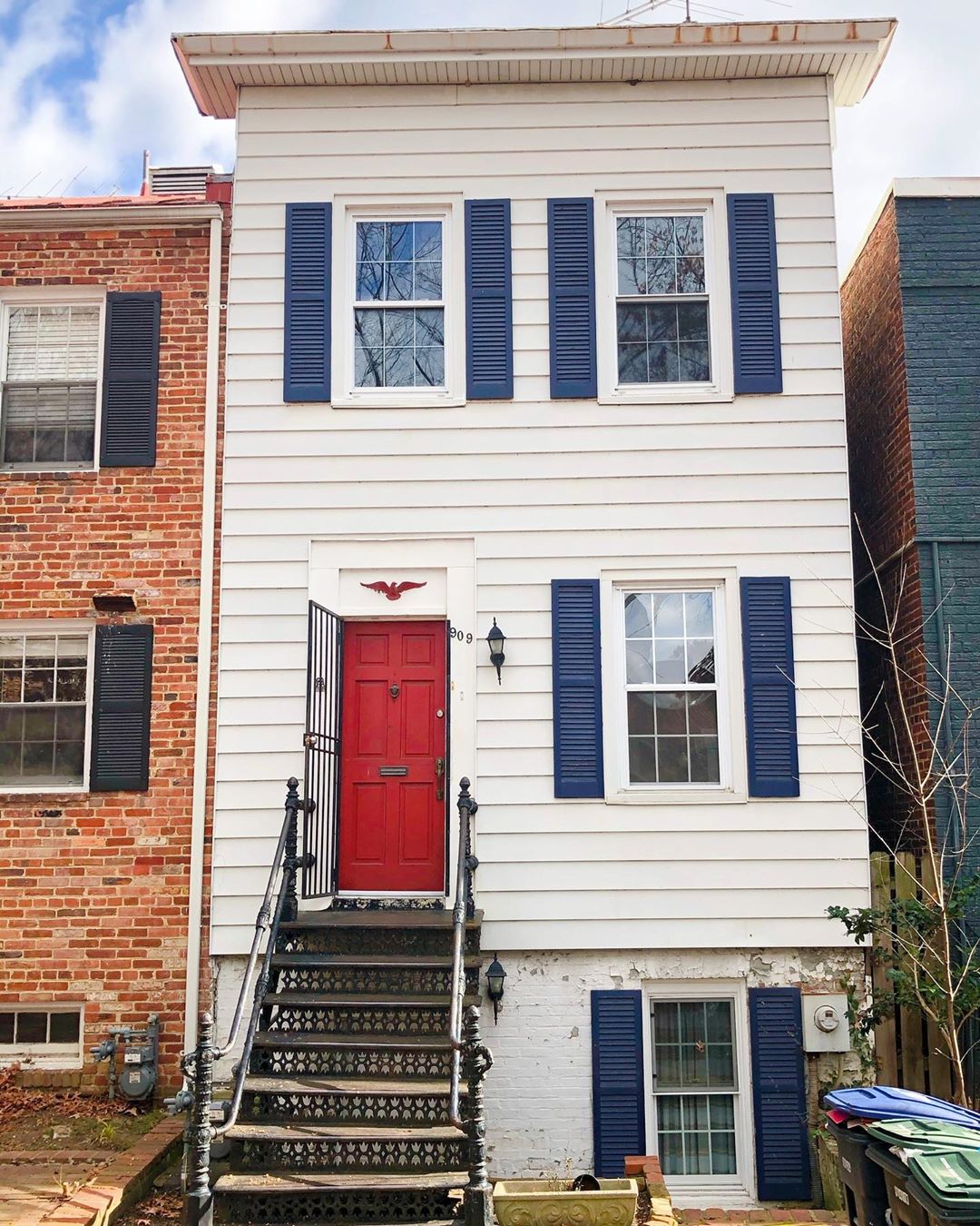 white Federal Style townhows with blue shutters and red door in Foggy Bottom, Washington, DC photo by Instagram user @penny.mause