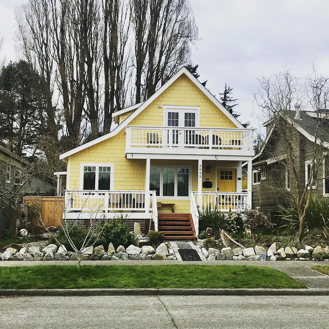 Yellow craftsman style home with white accents in West Seattle photo by Instagram user @dblh206.
