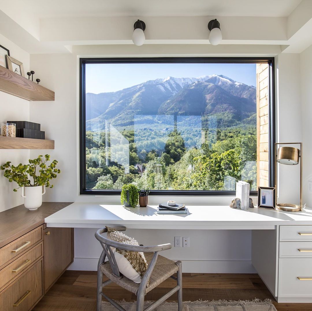 home office space with white floating desk with large window photo by Instagram user @splitrockcustomhomes