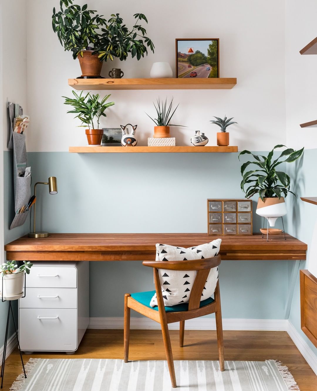 small home office with two-tone pain and floating wooden shelves photo by Instagram user @joyellewest