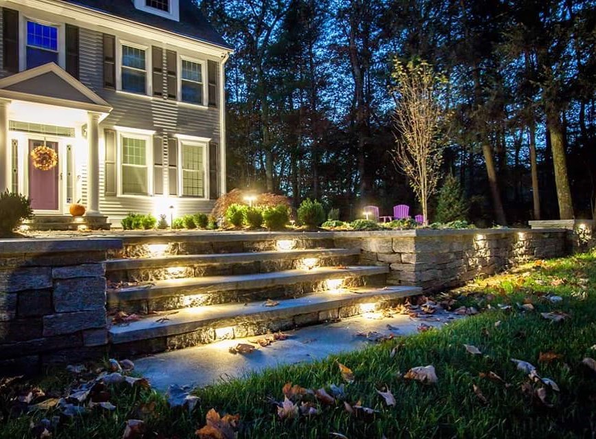 front yard landscaping with steps to front door illuminated by lights built into the light photo by Instagram user @integrallighting