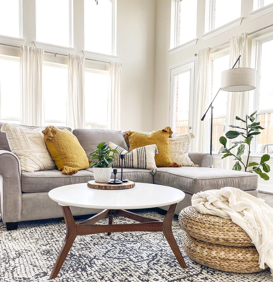 living room space with sectional and area rug with large floor to ceiling windows photo by Instagram user @diariesofmyhome