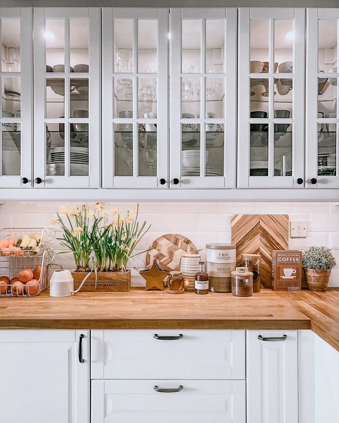 white kitchen cabinets with glass paned doors photo by Instagram user @love_lives_here