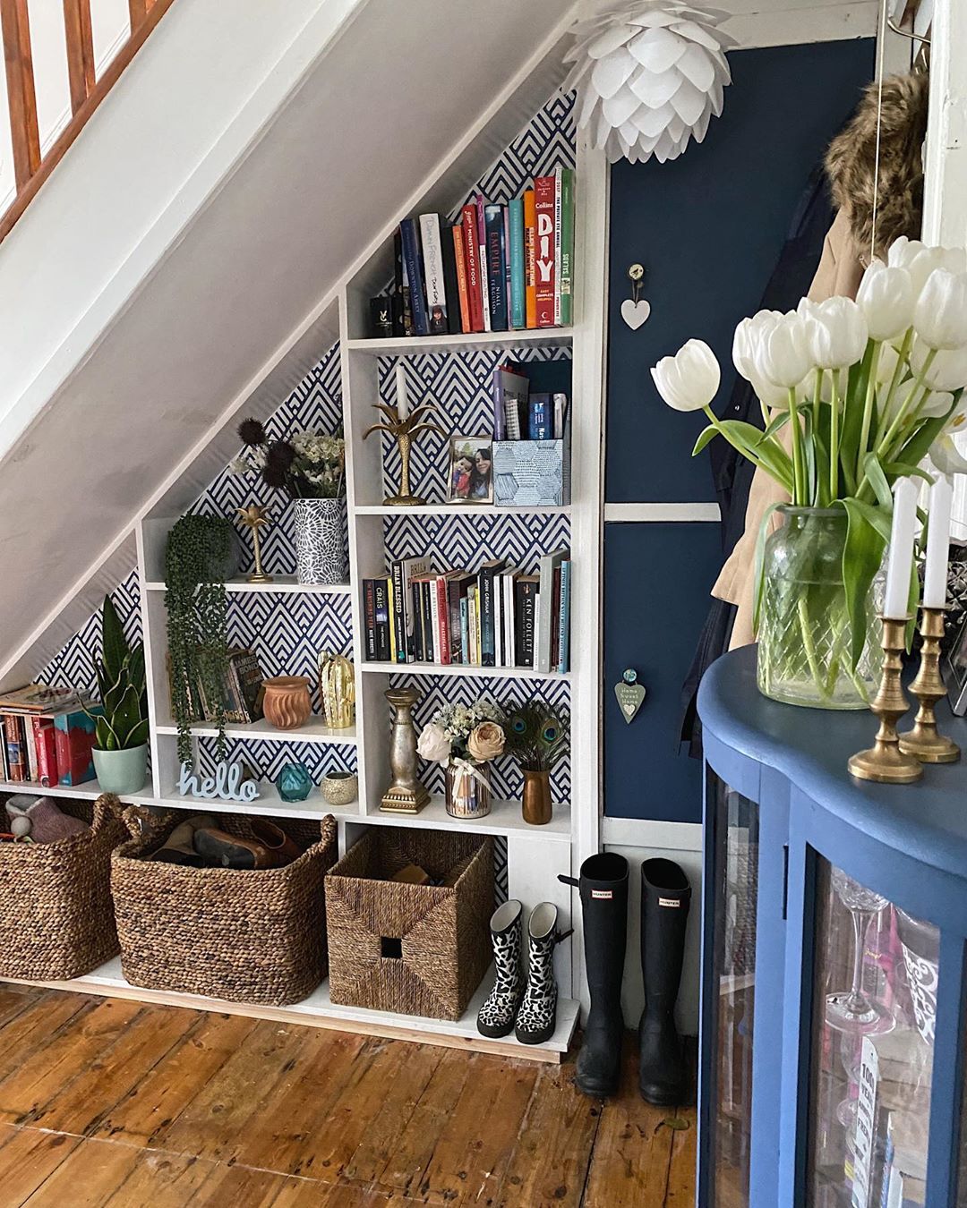 under stair storage space with shelves and woven baskets photo by Instagram user @melaniejadedesign