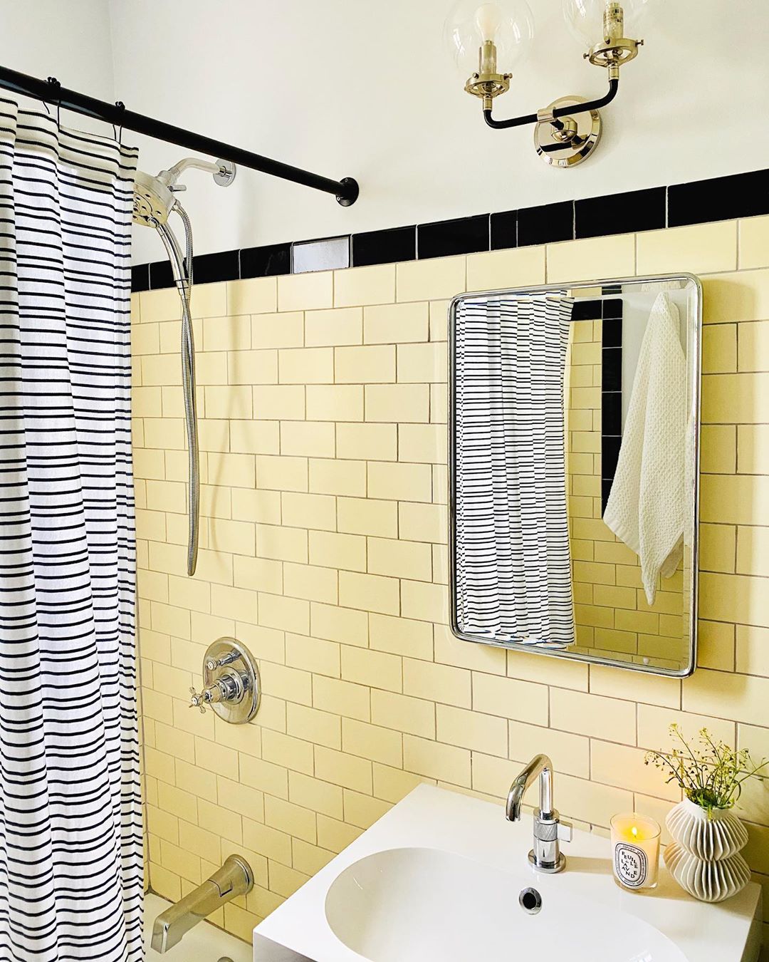 updated bathroom walls with yellow subway tiles and new light fixture photo by Instagram user @ipatrickdesign