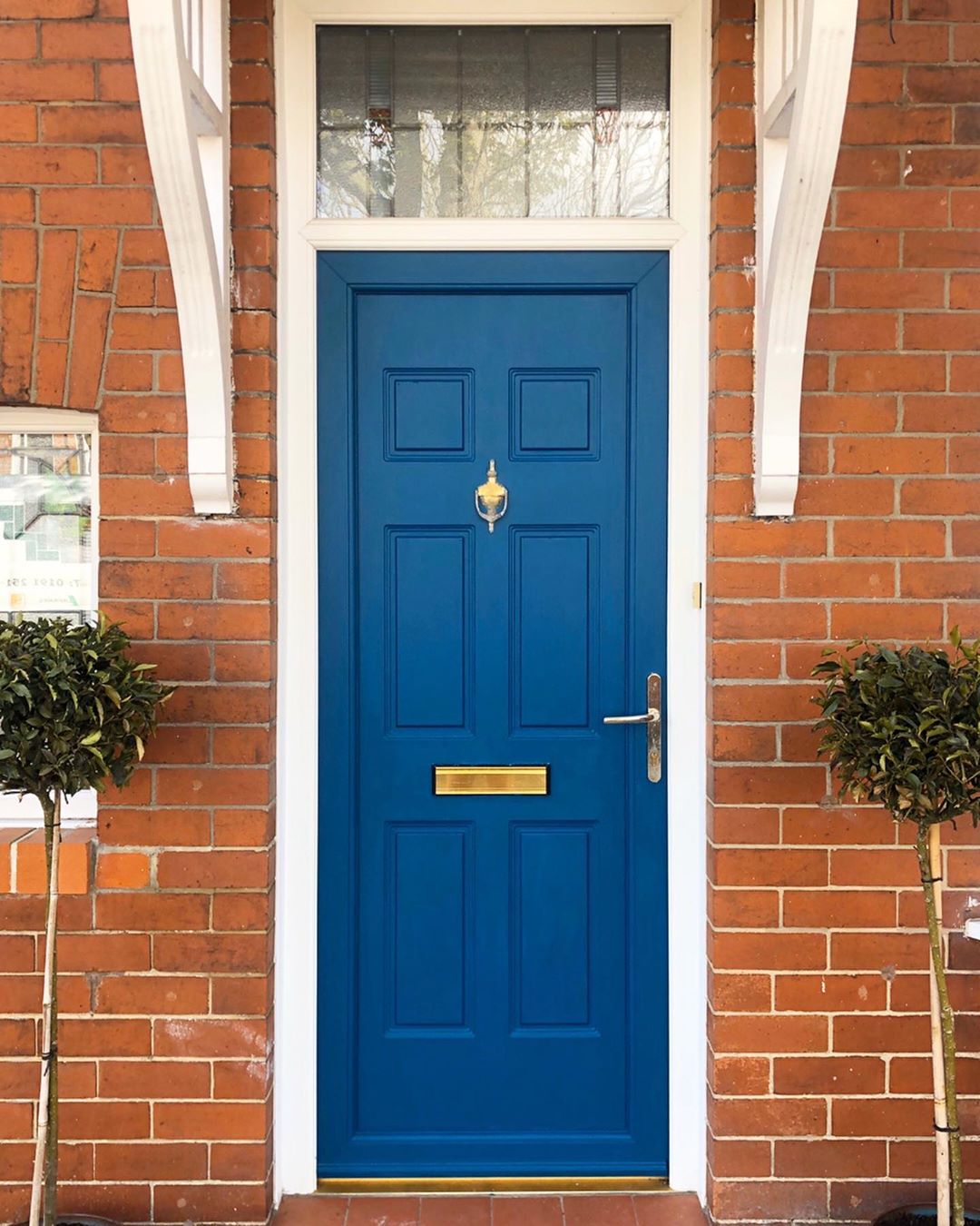 blue front door with plants on both sides photo by Instagram user @renovating_the_broadway