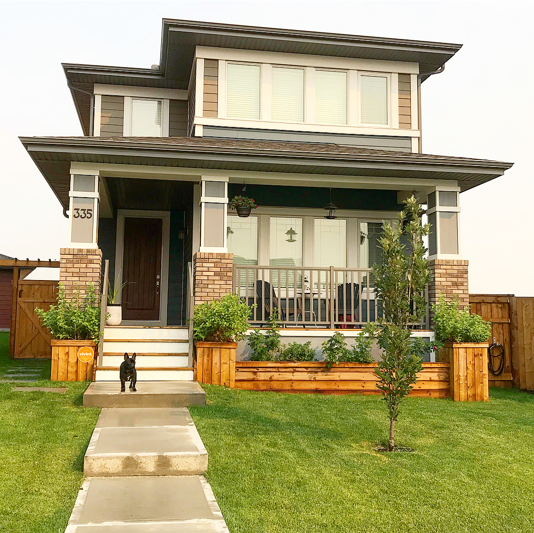 two story home with small tree planted and DIY wooden planters at the front of the house photo by Instagram user @bfulk.handmade